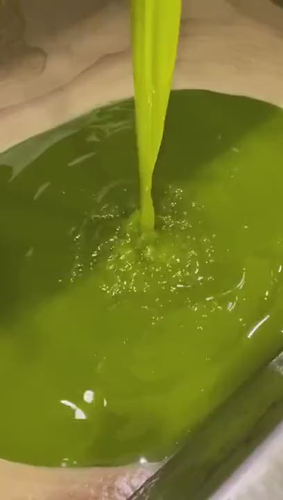 PLOUMI olive oil flowing into a stainless steel basin